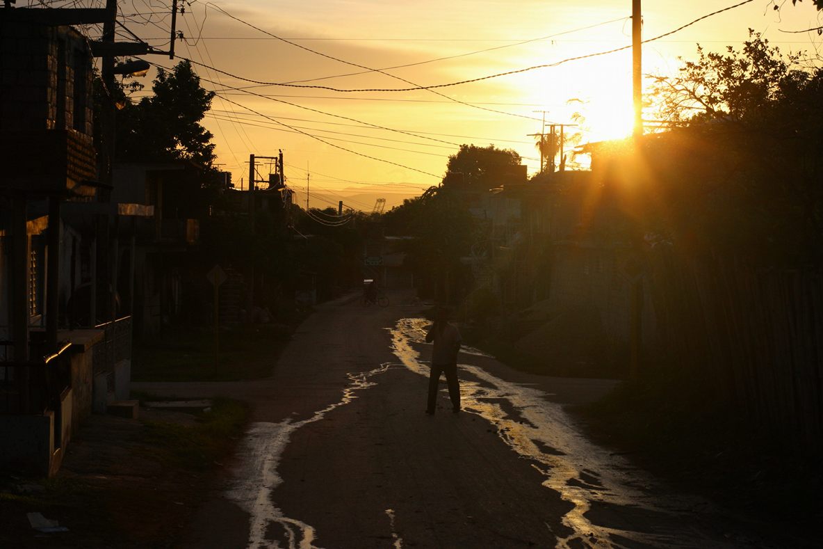 Straße mit Menschen im Gegenlicht der untergehenden Sonne