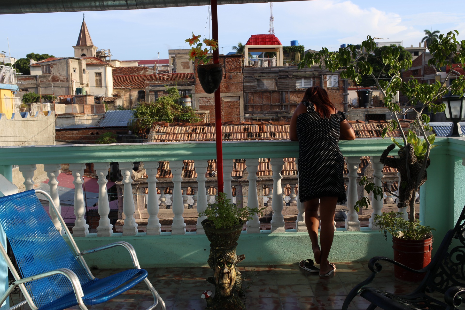 Frau steht auf einem Balkon mit Blick über eine Stadt