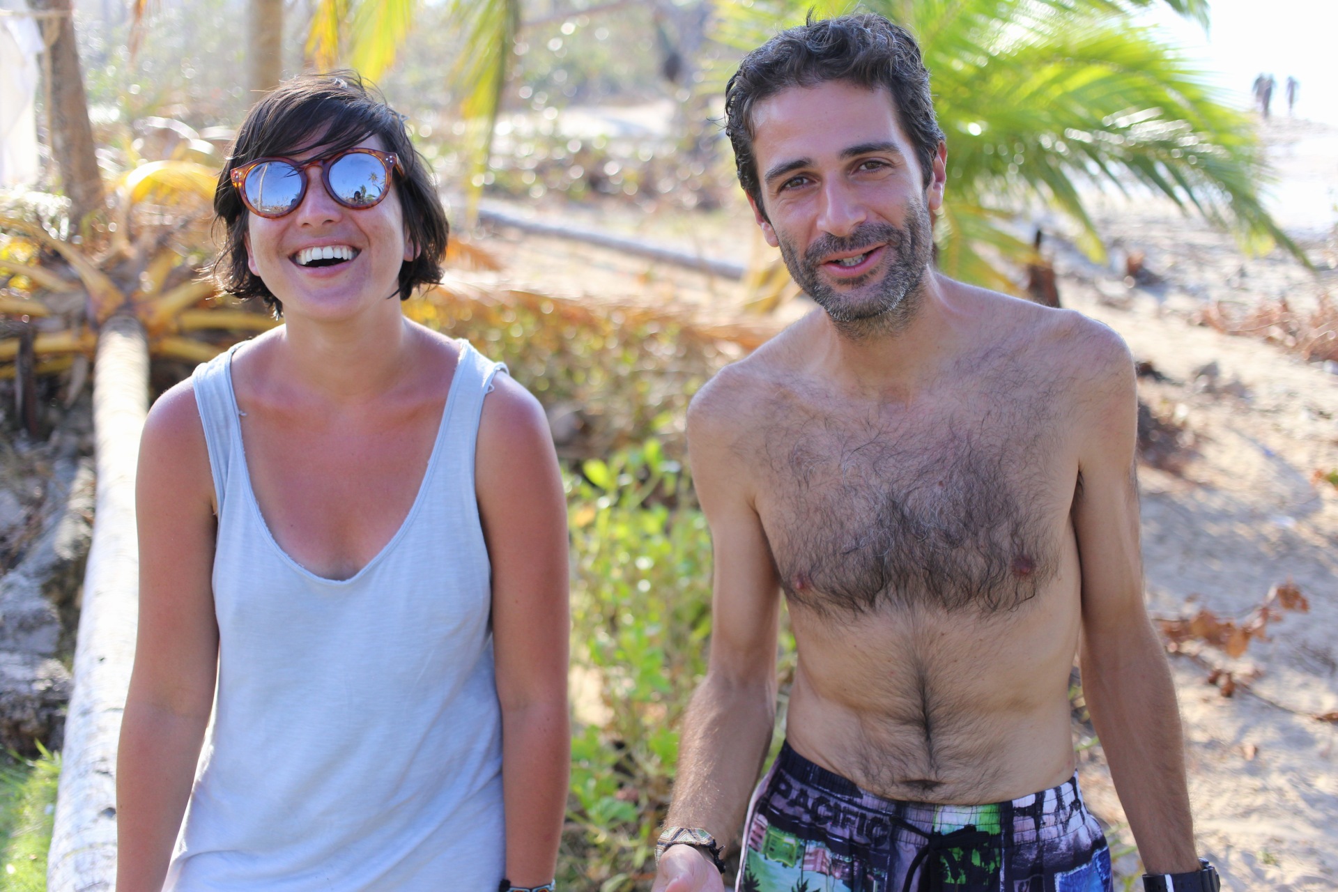 Frau und Mann lachen gemeinsam unter Palmen