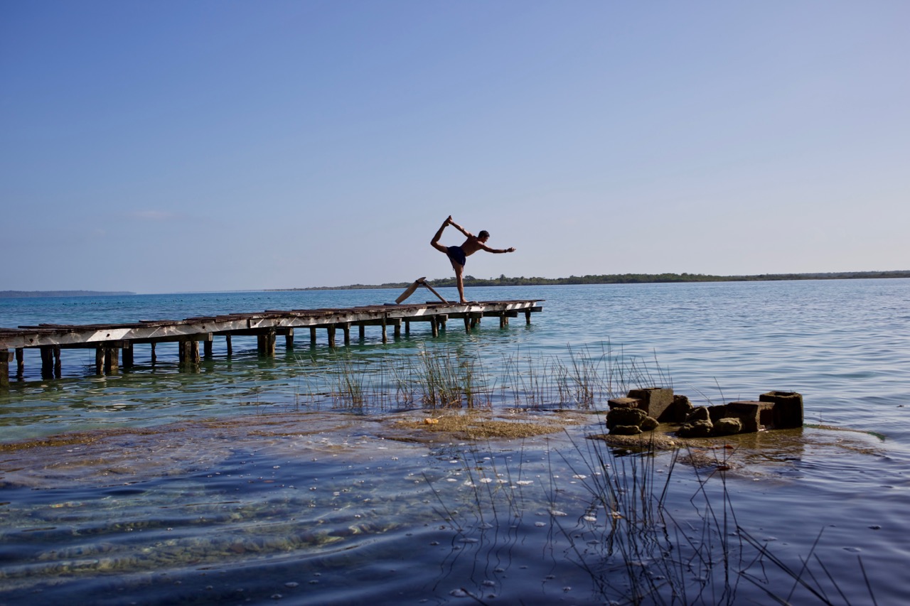 Steg auf dem See von Bacalar mit einer Person in Yogahaltung