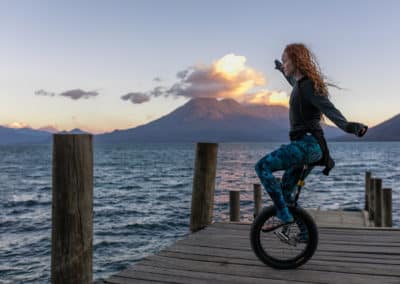 Frau auf einem Einrad auf einem Steg am Lago de Atitlán bei San Marcos, Guatemala