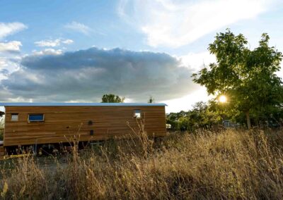 Holzbauwagen in hohem Gras unter weitem Himmel